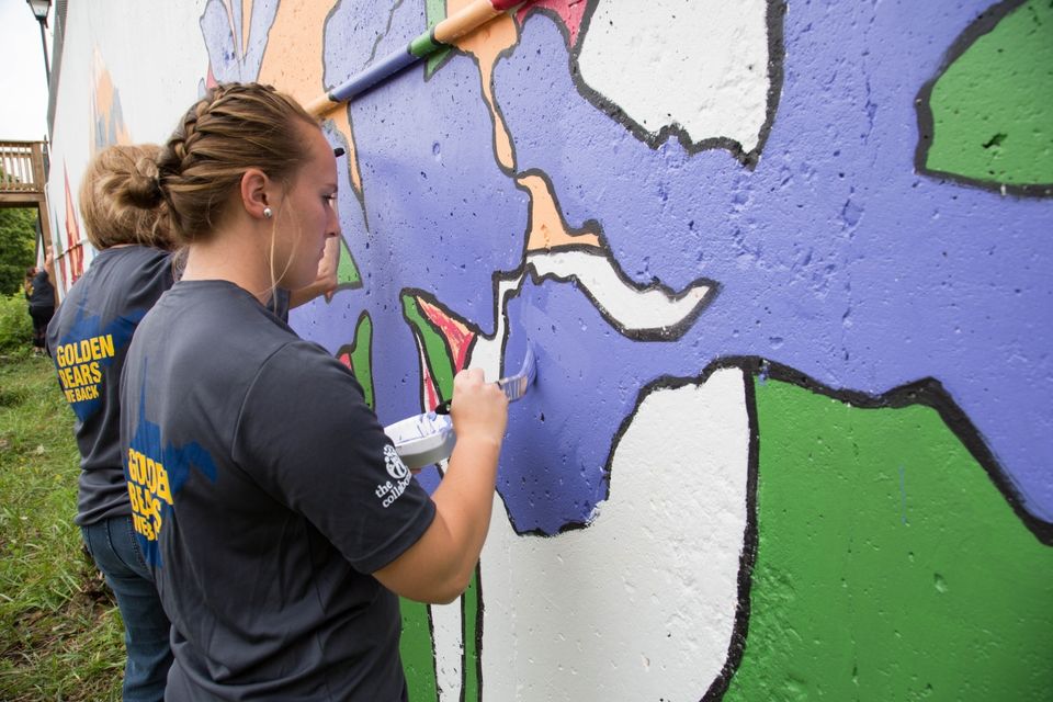 WVU Tech students paint a mural during a service project.